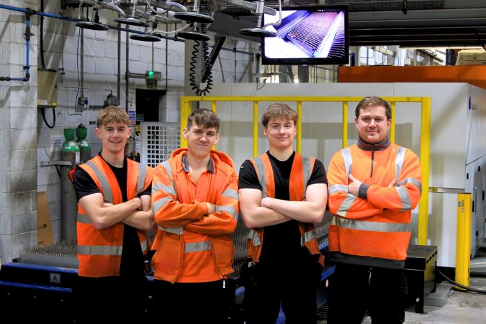 Wrightform team members standing with laser cutting machine