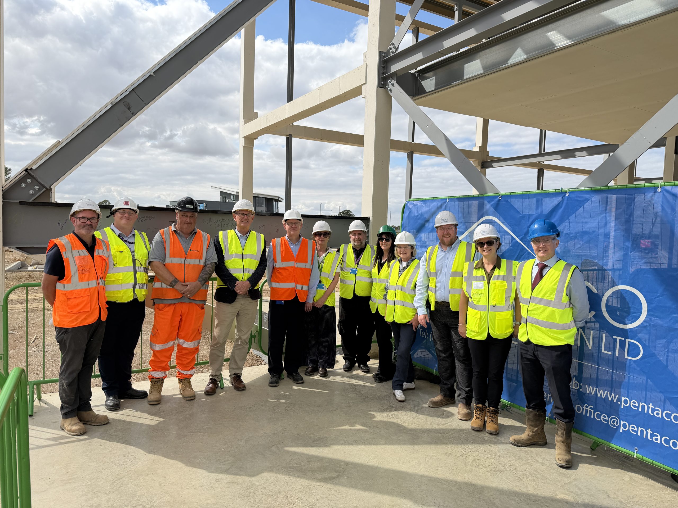 AME Centre partners pose in high vis jackets at the building site